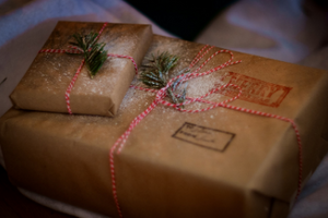 Two presents are wrapped in brown present wraps with a red and white rope tied over the middle section.