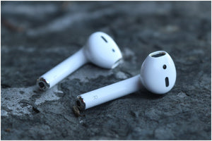 Airpods laying on a wet rock