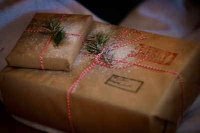 Two presents are wrapped in brown present wraps with a red and white rope tied over the middle section.